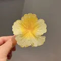 Dettaglio di un mollettone a forma di fiore plumeria giallo sfumato tenuto in mano - Taglia Grande 8 cm / Giallo alba