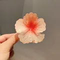 Close-up of a gradient peach frangipani hair claw clip with delicate resin petals - 8cm Large Size / Sunset Orange