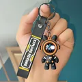 Detailed view of a trendy black astronaut bear keychain with an Explore Future printed strap - Roaming Four-Section Chain Style / Orange