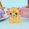 Macro view of a glitter-filled axolotl squeeze toy featuring a cute smiling face. - Orange