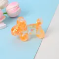 Close-up of a transparent orange balloon dog squishy toy with iridescent sequins. - Orange