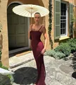 Elegant burgundy lace slim-fit evening gown dress worn by a model in a garden setting. - S / Burgundy