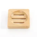 Close-up of a square bamboo soap dish with circular drainage slots and rounded corners. - Square Bamboo Soap Slippers 8x8x1.5 Cm (opp)
