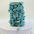 Detail of light blue beaded flower chain on a spool for DIY jewelry accessories - Gold Sky Blue
