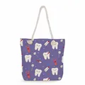 Detailed shot of a purple tote bag featuring cartoon tooth patterns and rope handles - Purple Oral Care Cartoon Style (ms4549)