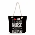 Close-up detail of nurse themed black tote bag with white slogan and rope handles - Black My Favorite Nurse Husband Quote Style (ms4559)