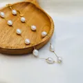 Elegant baroque pearl necklace with delicate gold beads displayed on a wooden tray - Golden White Shell Rice Bead Style