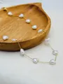 Close-up detail of a delicate gold chain necklace featuring heart-shaped shell beads - Golden White Shell Small Heart Style
