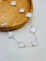 Close-up detail of white shell four-leaf clover charms on a delicate gold chain - Gold Four-leaf Clover Style