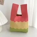 Primo piano di una borsa a mano in maglia colorata con motivi a zig-zag su un tavolo - Patchwork a Onde Rosa Giallo Verde