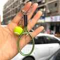 Detailed green tennis racket keychain with a mini tennis ball pendant held in hand - 2*9CM / Dark Green