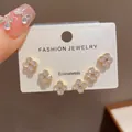 Dettaglio di tre paia di orecchini a lobo a quadrifoglio con cristalli su cartoncino - #1 Oro - Set Di Tre Orecchini A Quadrifoglio Con Diamanti (placcatura In Oro Massiccio)