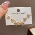 Detailed view of a three-piece gold stud earring set featuring heart and bow designs. - 20# Gold - Fully Rhinestone Heart Bow Three-piece Set (thickened Real Gold Plating)