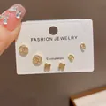 Elegant 3-piece golden stud earring set with clover and logo designs on display card - 57# Gold - Fully Diamond Chanel-style Four-leaf Clover Three-piece Earring Set (thickened Real Gold Plating)