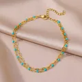 Detailansicht einer goldenen Edelstahl-Doppelfußkette mit blauen Evil Eye-Perlen. - Blauer Böser Blick Stil (HJ385G)