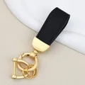 Elegant black textured leather car keychain with gold-tone D-ring hardware and bag charm - Independent Matte Bag Packaging / Pearl Gold-Black