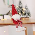 Detailed view of a red plush Christmas gnome doll sitting on a wooden table edge with bokeh lights. - Red Hat With Beard