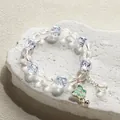 Ethereal crystal beaded bracelet with a green butterfly pendant and bell charm detail - Butterfly Bell Ice Bracelet Blue