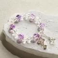 Ethereal crystal beaded bracelet featuring purple crackle beads and a golden butterfly charm - Butterfly Bell Ice Bracelet Purple