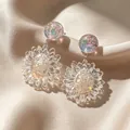 Vintage iridescent resin flower drop earrings displayed on champagne satin sheet - Transparent Daisy Flower Earrings (2606137)