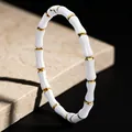 Pulsera de nudo de bambú de acero de titanio blanco y oro con un acabado pulido. - Pulsera de Bambú Blanco