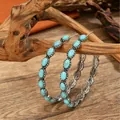 Bohemian style vintage hoop earrings featuring turquoise beads displayed on driftwood - White K (9807)