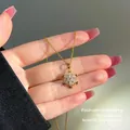 Elegant gold-plated snowflake necklace featuring sparkling crystal stones held in hand. - 128#xl1439-snowflake-gold