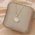 Elegant gold Saturn necklace with white gemstone and star detail on a display stand - 129#XL1452-09