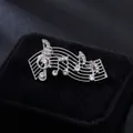 Elegant silver music note brooch with shimmering crystals on a black velvet background - Creative Music Note Silver (XD826059)