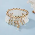 Böhmisches mehrlagiges Perlenarmband-Set mit goldenen Akzenten und Kugelanhänger - Weiß
