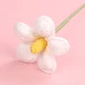 Handmade white crochet flower with yellow center and green stem on pink background - Plumeria Branch / White