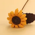 Handmade crochet sunflower with yellow petals and brown center on beige background - Mengsi Afghan Cream Sunflower / Dark Yellow