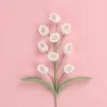 Handmade crochet lily of the valley flower with white blossoms on a pink background - 9-Head Lily of the Valley Branch / White