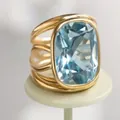 Nahaufnahme eines quadratischen hellblauen Kristallrings mit goldfarbenem Band - Größe 6