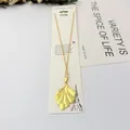 Gros plan d'un pendentif en feuille de ginkgo dorée sur une fine chaîne en inox. - Style Feuille de Ginkgo 3D / 40cm+6cm