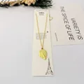 Détail d'un collier avec pendentif feuille dorée sur une carte cadeau. - Style Feuille Fine / 40cm+6cm