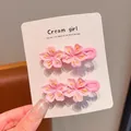 Vista dettagliata di dolci fermagli per capelli a fiori rosa su scheda espositiva. - Piccola clip a becco d'anatra rosa fiori di pesco