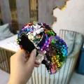 Dettaglio ravvicinato delle paillettes arcobaleno su un cerchietto annodato alla moda - Colorato