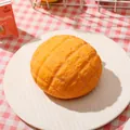 Realistic pineapple bun squishy toy for stress relief presented on a white plate - One Pineapple Bun (flour-based)