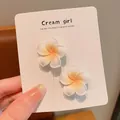 Close-up detail of white plumeria flower hair clips on a Cream girl display card - Large Frangipani Yellow Small Clip