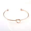 Eleganter Armreif aus roségoldenem Edelstahl mit einem minimalistischen Knotendesign - Roségold