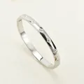 Brazalete de acero inoxidable plateado pulido con patrones de estrellas grabados y diamantes - Color Acero (ar2055)