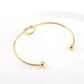 Eleganter minimalistischer vergoldeter Knoten-Armreif aus Titanstahl mit Perlenenden - Gold