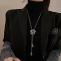 Nahaufnahme einer silberfarbenen Rosen-Halskette mit Kristallakzenten auf schwarzem Outfit - Schwarze Rose Halskette (001)