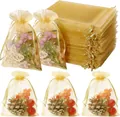 Stacked gold organza drawstring bags and filled gift pouches shown with floral decor. - Gold / 7*9cm