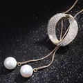 Close-up of elegant gold sweater chain with sparkling rhinestone pendant and twin pearls - Gold Circle Style (023)
