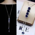 Detail view of long silver titanium steel sweater chain with blue crystal pendants - Long Bar Circle Necklace (025)