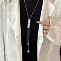 Detail view of elegant titanium steel long necklace with white cat eye stones on model. - Cat Eye Long Bar Necklace (462)