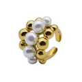 Gros plan détaillé d'une bague ouverte en acier inoxydable doré avec perles - Doré