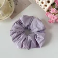 Dettaglio di un elastico per capelli in tessuto viola lavanda con trama a pieghe - Viola